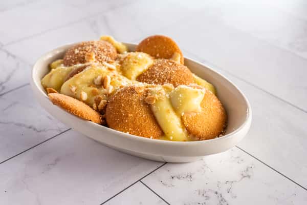 banana pudding dessert with vanilla wafers, creamy custard, and crushed cookie topping