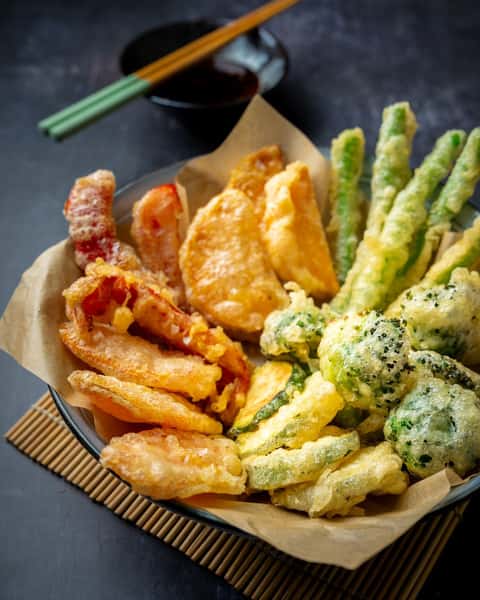 Craving something crispy and delicious? Look no further than Koi Pond's famous Vegetable Tempura! 🤤 Made with lotus root, asparagus, broccoli, zucchini, and sweet potato, and served with a variety of mouthwatering sauces. 😍 It's no wonder why it's our most popular dish! 👀 Come taste it for yourself today! #KoiPond #VegetableTempura #CrispyCravings #SavorTheFlavor