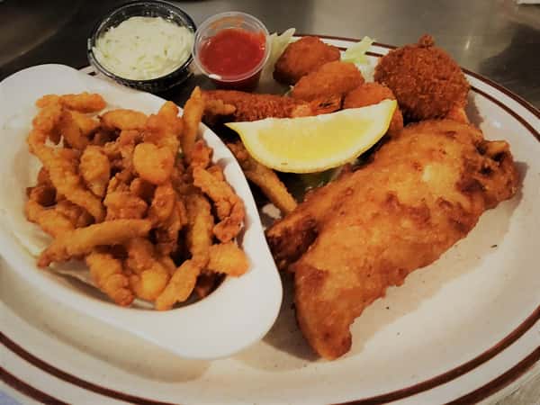 fish, shrimp, hush puppies with a lemon wedge and coleslaw