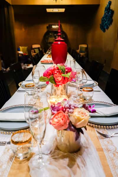 elegant private dining table setup with floral centerpieces, candles, and fine glassware in an intimate restaurant setting