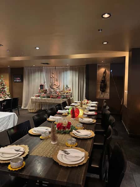 private dining room with long communal table, elegant holiday place settings, and festive decorations for group dining at Thai restaurant