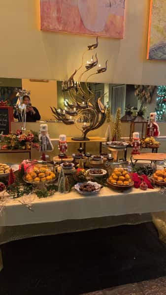 festive dessert buffet table with assorted pastries, cakes, and holiday decorations in elegant Thai restaurant setting