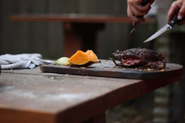 Chef preparing grilled steak at Sivas Tavern with upscale dining and modern restaurant ambiance