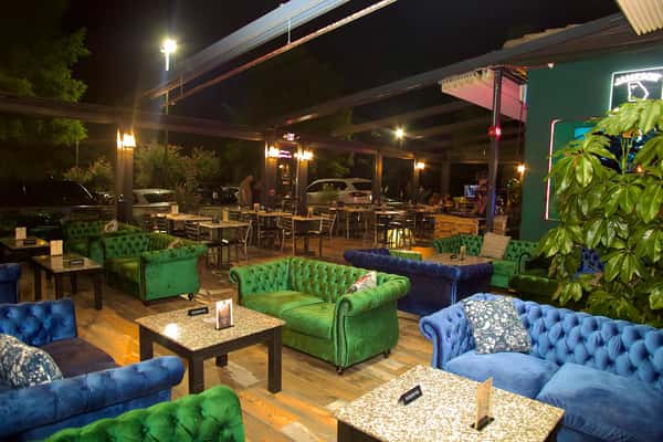 Outdoor patio seating at Sivas Tavern with stylish lounge furniture and vibrant nighttime dining atmosphere