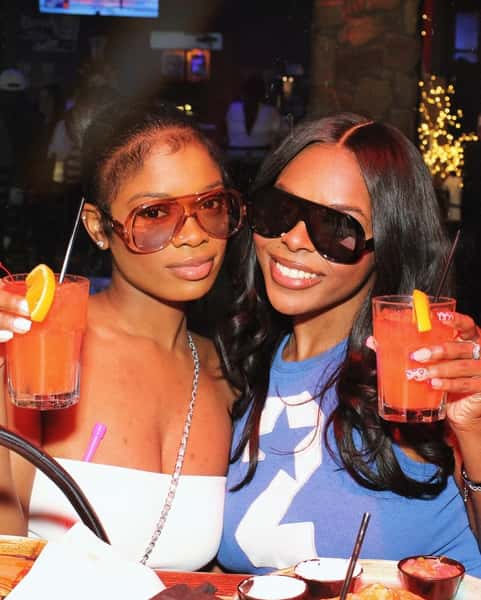 Two guests posing with cocktails at Sivas Tavern featuring stylish nightlife vibes and upscale lounge atmosphere