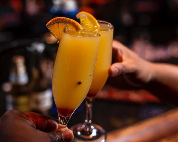 Refreshing orange brunch cocktail at Sivas Tavern with citrus garnish and upscale lounge ambiance