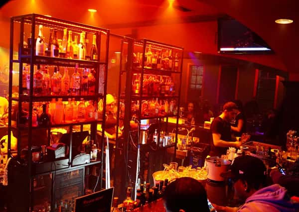 Warmly lit bar interior at Sivas Tavern featuring premium liquor displays and upscale nightlife ambiance