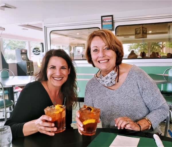 Two women holding drinks in their hands