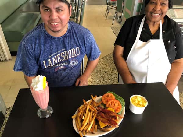 2 employees with a burger, fries and shake