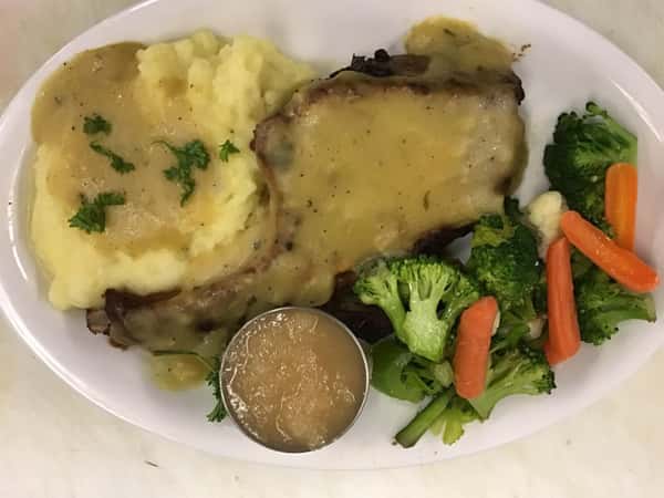 steak and potatoes in gravy with side of carrots and broccoli