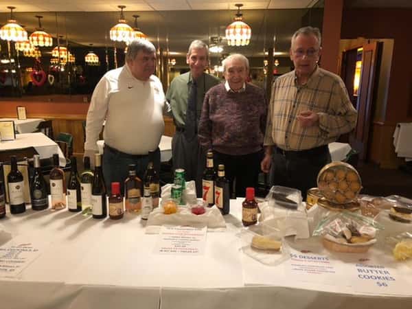 men at display table with liquor display