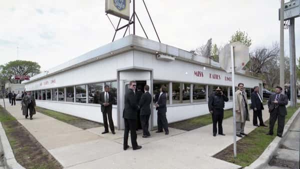 outside of diner with several people in suits