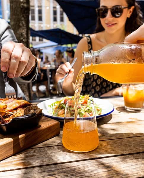 Guests enjoying entrees while a waitress refills a drink