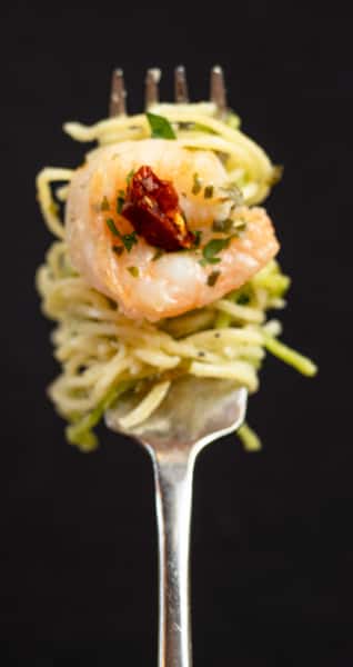 Spinach and Egg Angel Hair pasta wrapped around a fork with a sautéed shrimp and sundried tomato.