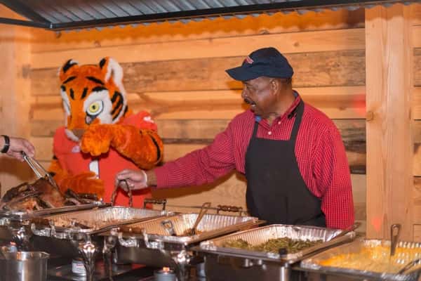chef serving food next to tiger mascot