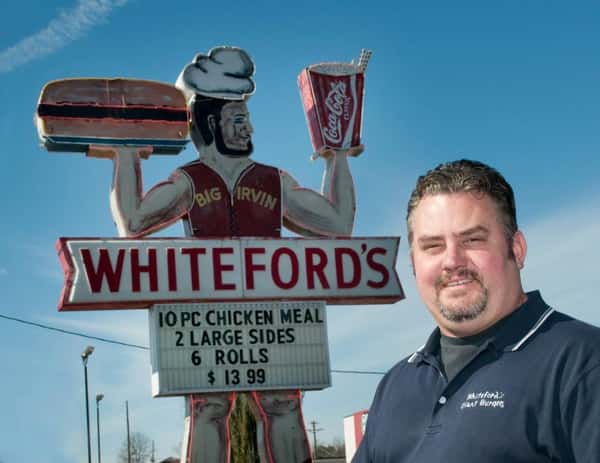 Owner next to iconic sign