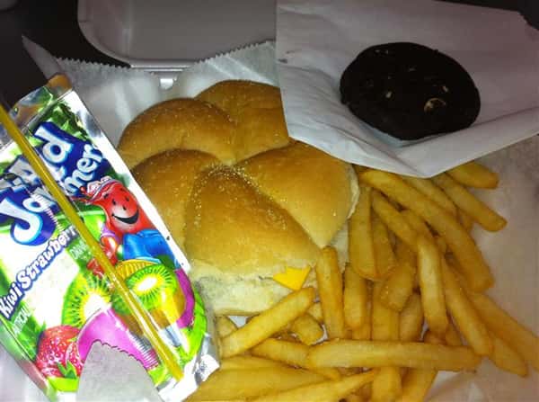 A cheeseburger with french fries, a cookie, and a kool aid juice box on the side