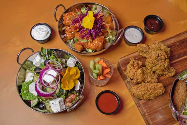 Assorted Mediterranean dishes including rice bowls, fresh salad, dips, and crispy fried food