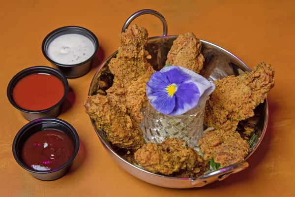 Lemon pepper wings served with dipping sauces and a flower garnish