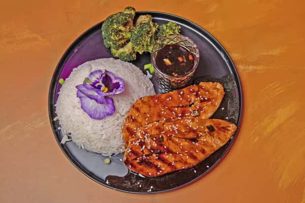 Teriyaki glazed chicken plated with rice and vegetables