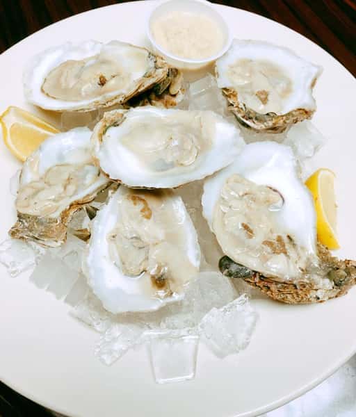 oysters on the half shell with lemon wedges