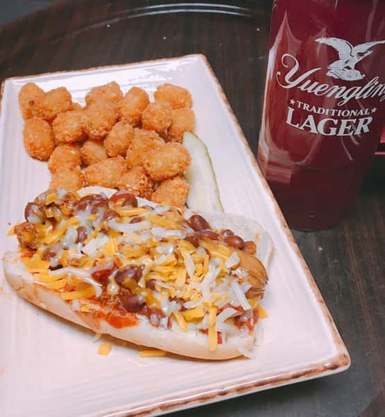 chili dog on a roll with tater tots