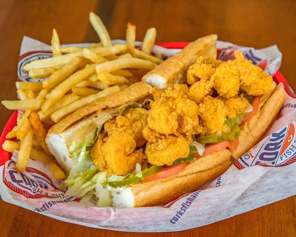 Fried shrimp po' boy topped with lettuce and served with French fries.