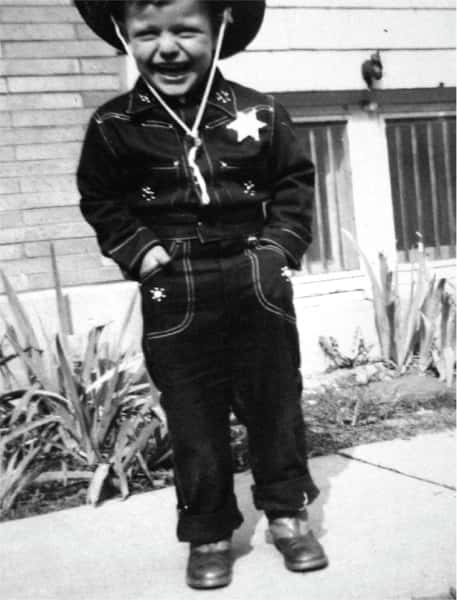 old black and white photo of Comella's family member boy dressed in a cowboy sherrif's costume