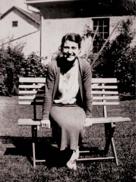 old black and white photo of Comella's family member a lady sitting on a bench