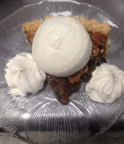 a lice of pecan pie, topped with whipped cream