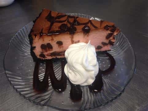 a slice of chocolate pie, topped with a chocolate drizzle and whipped cream