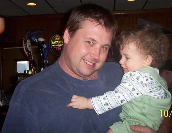a man holding a toddler at the bar