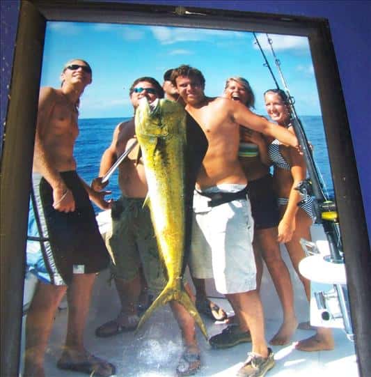 a framed photo of a man proudly holding a large fish