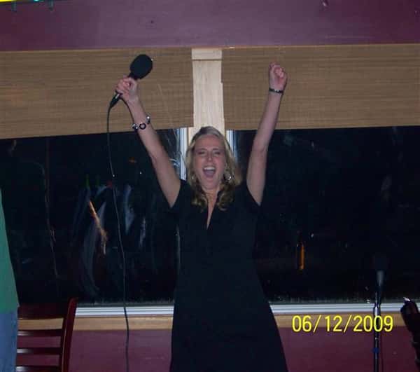 Suzanne, triumphantly holding a Karaoke microphone