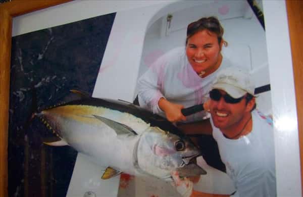 a framed photo of a couple in a boat holding a large fish