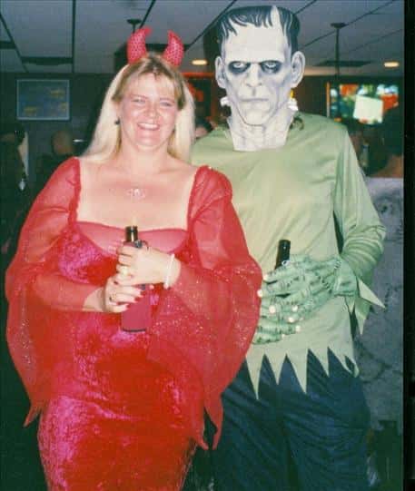 a woman dressed as a devil with a man dressed as Frankenstein's Monster
