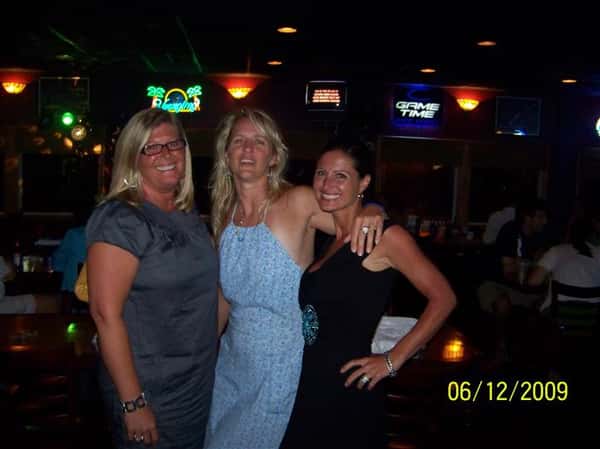 three women happily posing at the bar