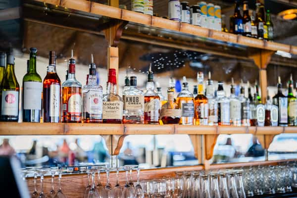 fully stocked restaurant bar with liquor bottles and glassware in a lively casual dining atmosphere