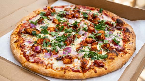 BBQ chicken pizza with melted mozzarella, diced red onion, and fresh cilantro.