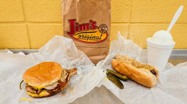 Jim's Original Maxwell Street Polish sausage, pork chop sandwich, and beverage on a tray.
