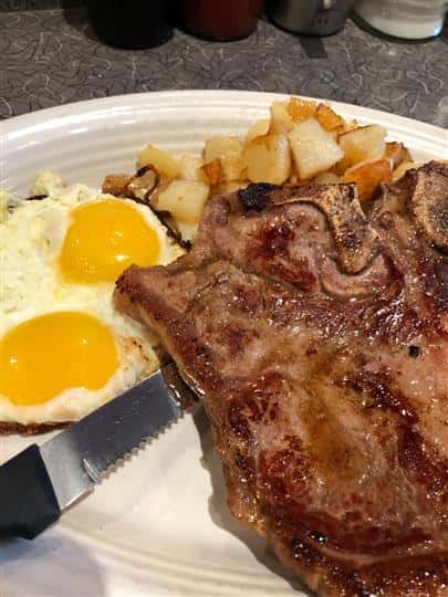 Steak and two eggs with side of potatoes