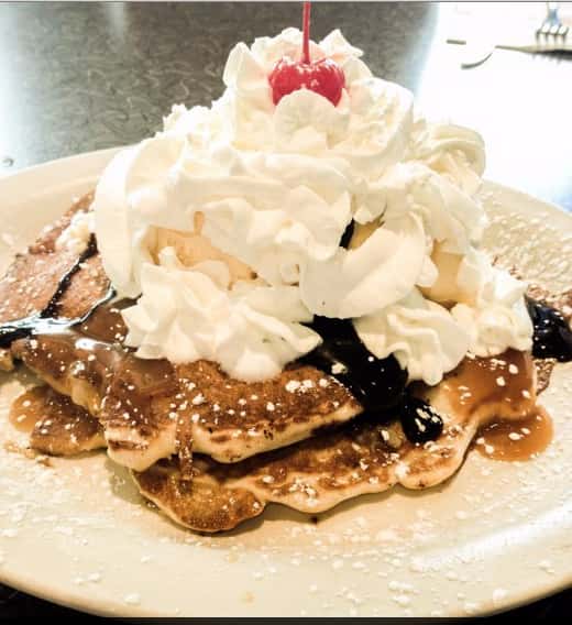 pancakes with chocolate syrup and whipped cream
