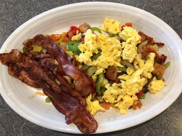 scrambled egg omelette with peppers and a side of bacon on a plate
