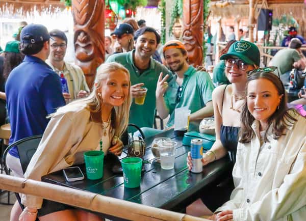 Friends smiling and sharing appetizers and drinks on the patio.