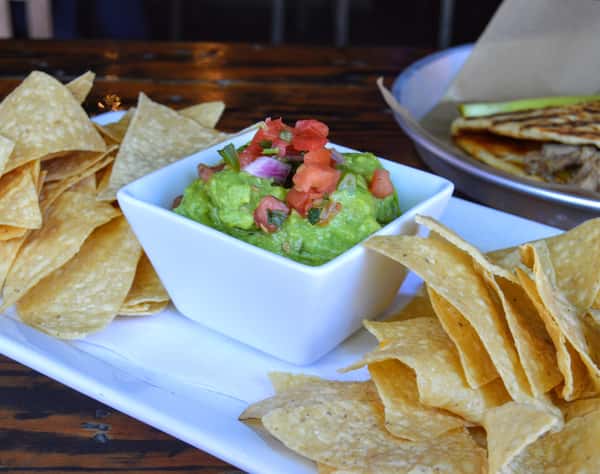 Fresh guacamole topped with cotija cheese served with warm tortilla chips