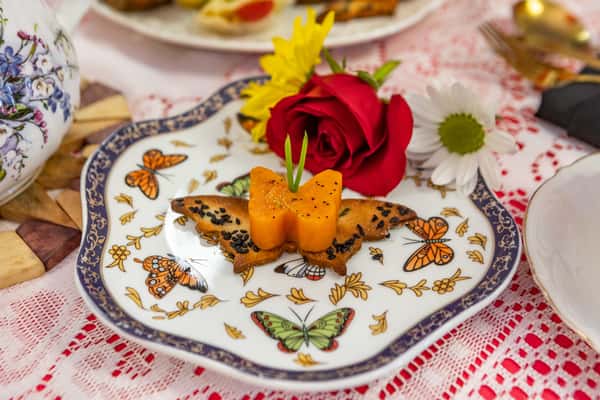 Savory butterfly-shaped pastry topped with a carrot butterfly cutout and black sesame seeds, served on a butterfly-patterned plate.