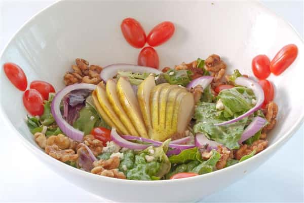 Salad consisting of evenly sliced lemons, lettuce, pecans, and sliced onions
