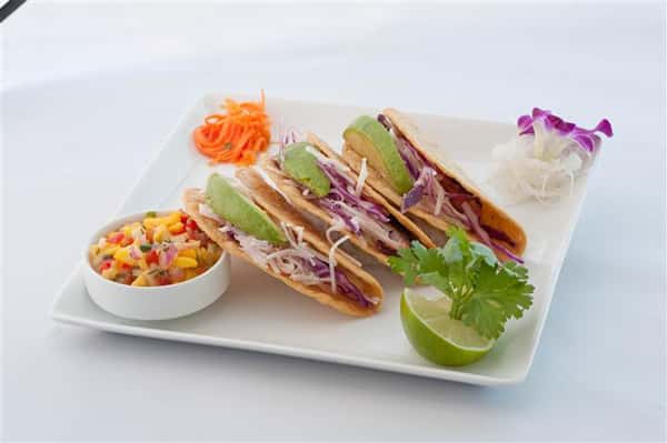 vegetarian Tacos served along with a lime slice and vegetables