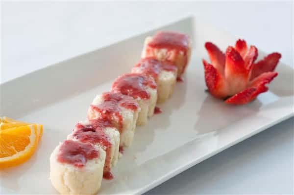Sushi Platter containing 6 rolls complimented with 2 orange slices and a elegantly cut strawberry