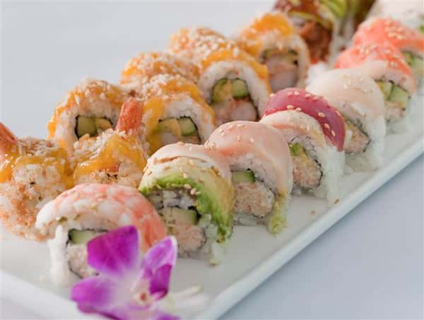 Sushi platter with a plethora of different sushi rolls served with a flower garnish